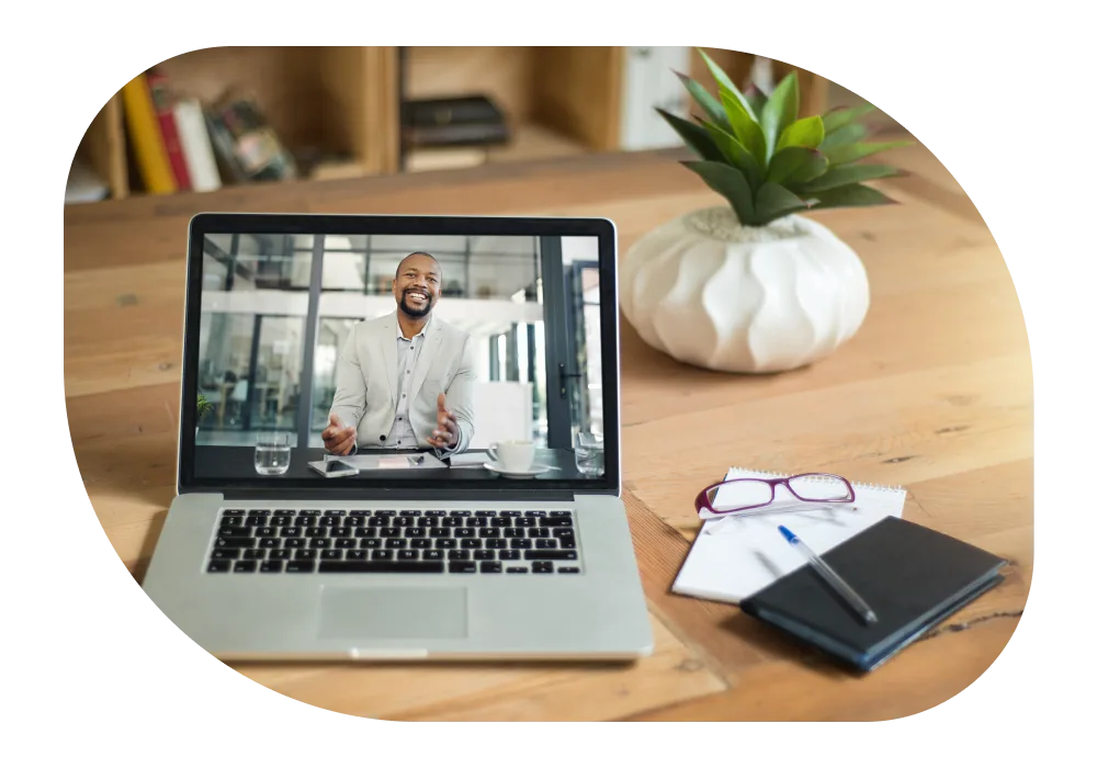Laptop featuring a smiling man within a videoconference.