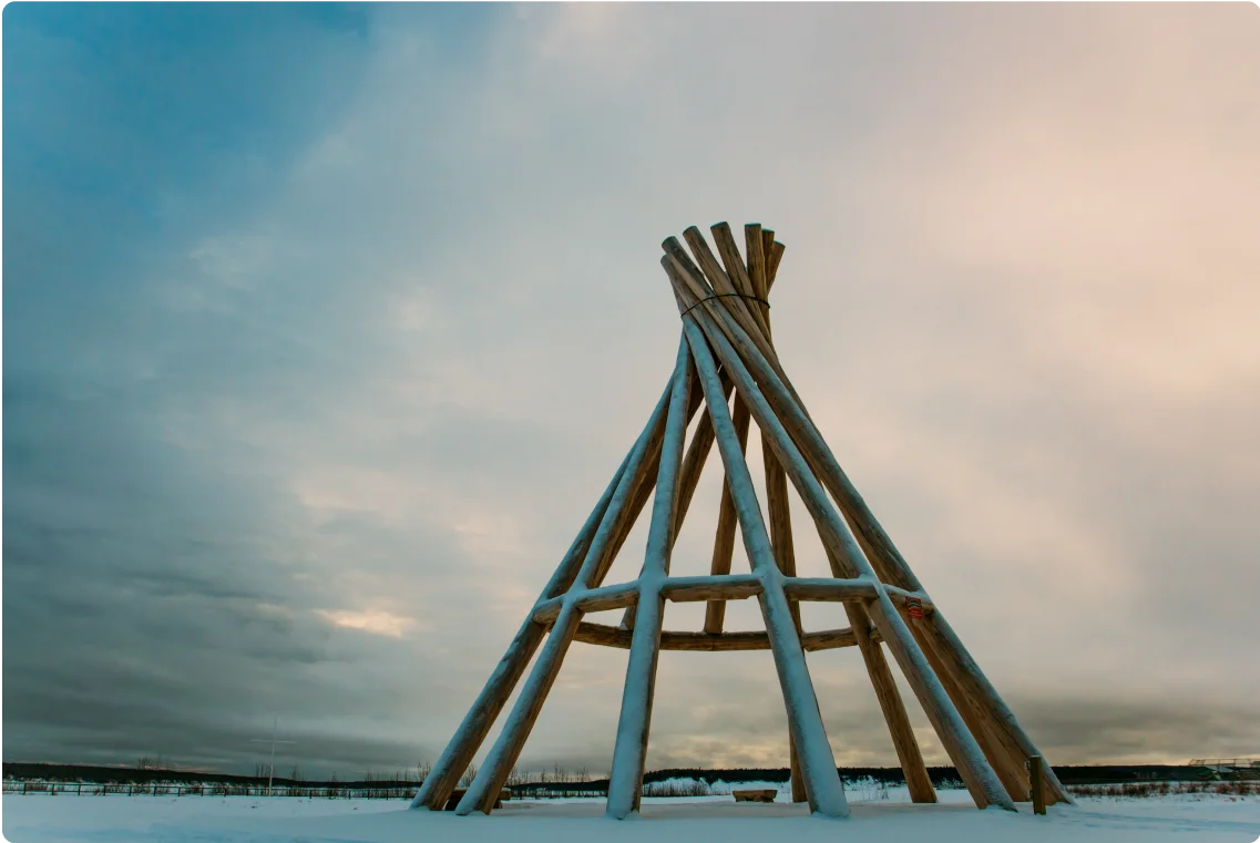 A photograph of a snow covered teepee in a field in Fort Simpson